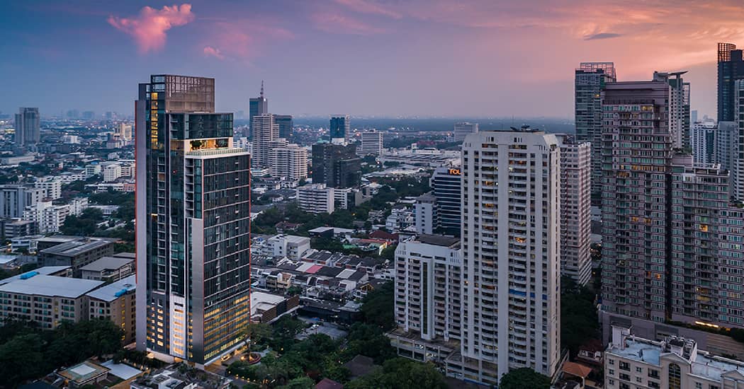 KRAAM Sukhumvit 26 tower at dusk among Sukhumvit high-rises