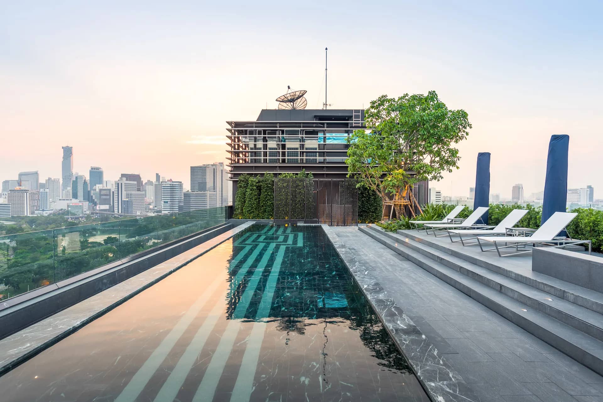 Sindhorn Tonson rooftop pool with Lumpini skyline at dusk