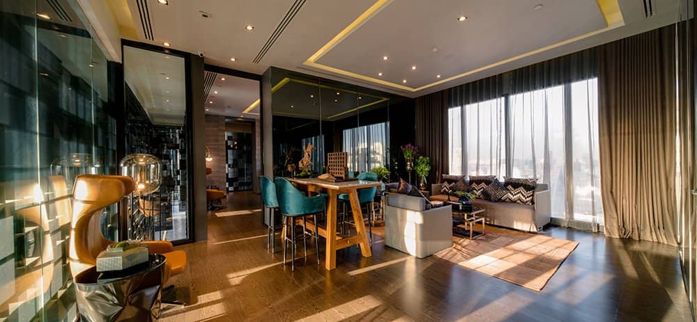 Ashton Asoke lounge with bar counter and floor-to-ceiling city windows