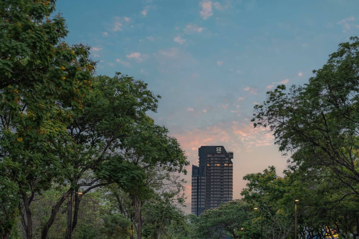 COCO Parc tower rising above trees at dusk