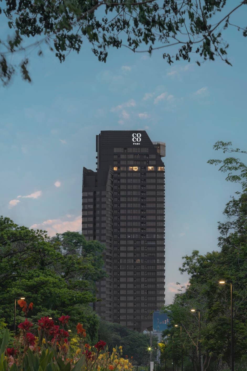 COCO Parc tower with lit windows at dusk seen from the street