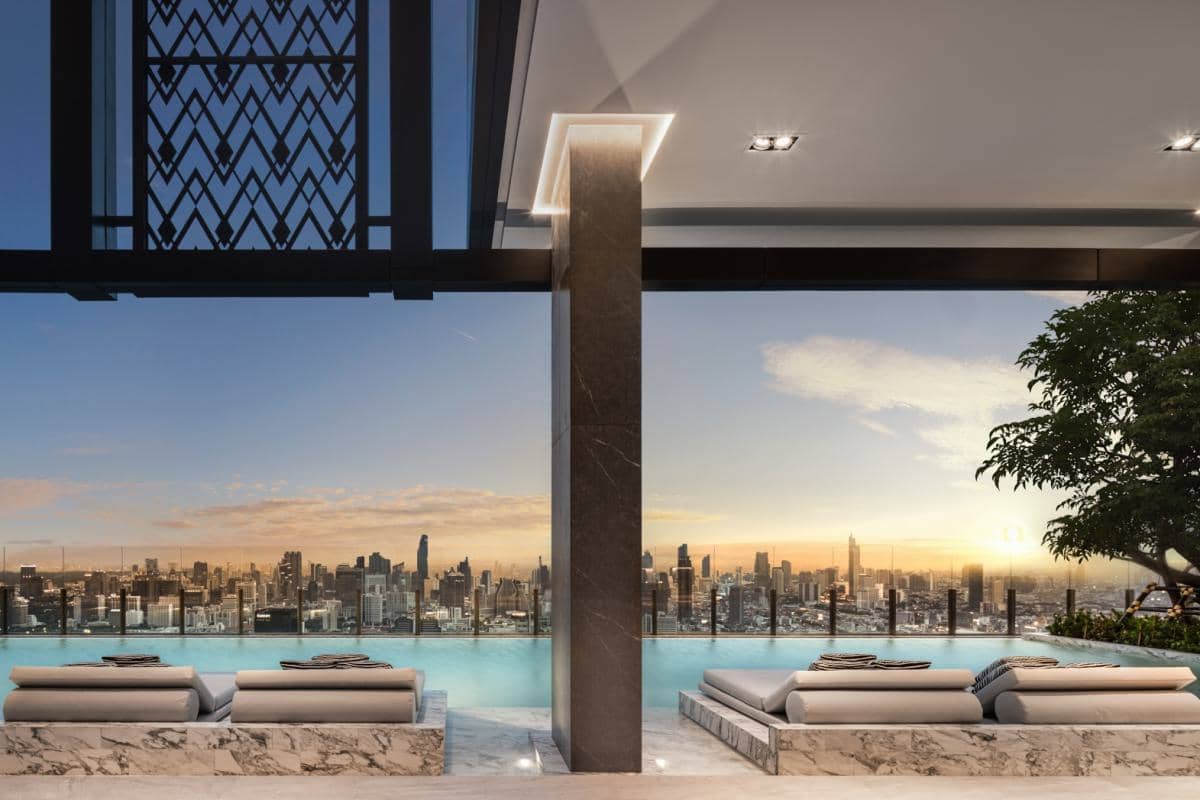 The Address Siam infinity pool with sun loungers และ skyline at sunset