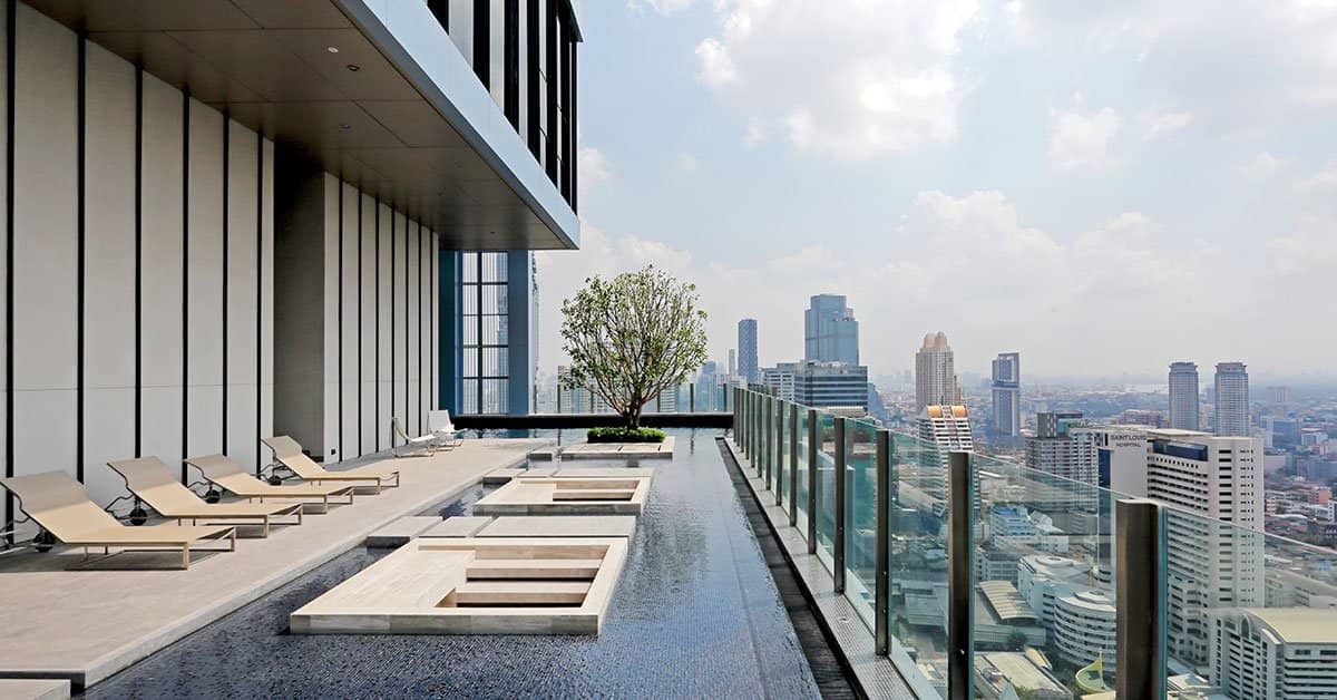 The Diplomat Sathorn rooftop pool with sun loungers and city view