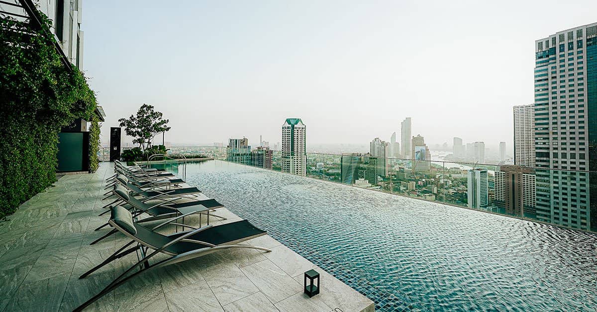 The Lofts Silom rooftop infinity pool with lounge chairs overlooking the city skyline