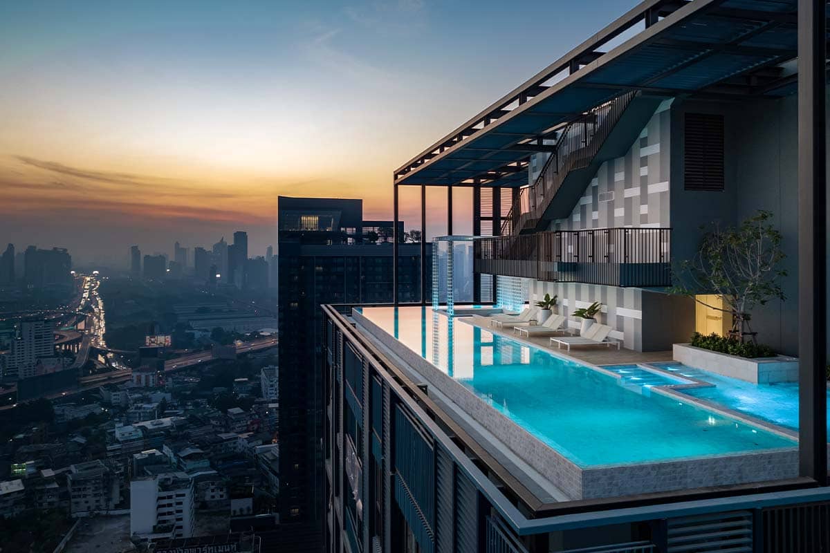 XT Phayathai rooftop infinity pool with loungers at sunset