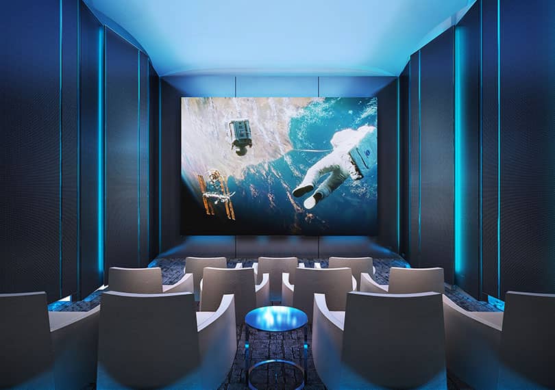 Hyde Sukhumvit 11 private theatre room with blue ambient lighting and reclining seats facing a large screen